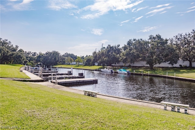 view of dock with a yard and a water view