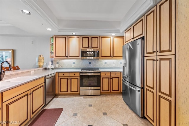 kitchen with appliances with stainless steel finishes, a raised ceiling, recessed lighting, light countertops, and a sink