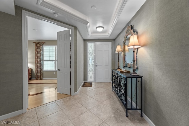 entryway with a raised ceiling and light tile patterned floors