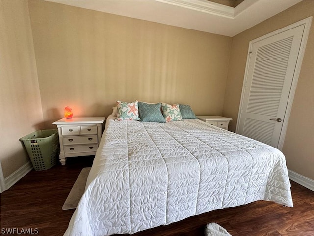 bedroom with dark wood-type flooring and a closet