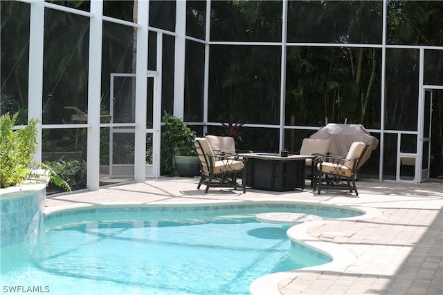 view of swimming pool with a patio, a lanai, and a grill