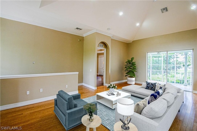 living room with hardwood / wood-style flooring, vaulted ceiling, and crown molding