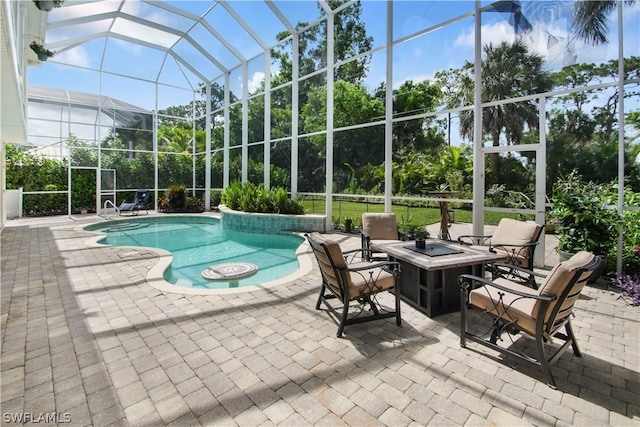 view of pool with a fire pit, a patio, and glass enclosure