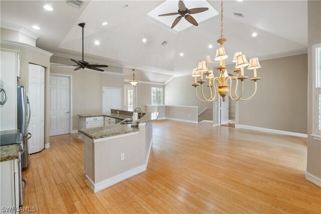 kitchen featuring sink, lofted ceiling, decorative light fixtures, and ceiling fan with notable chandelier