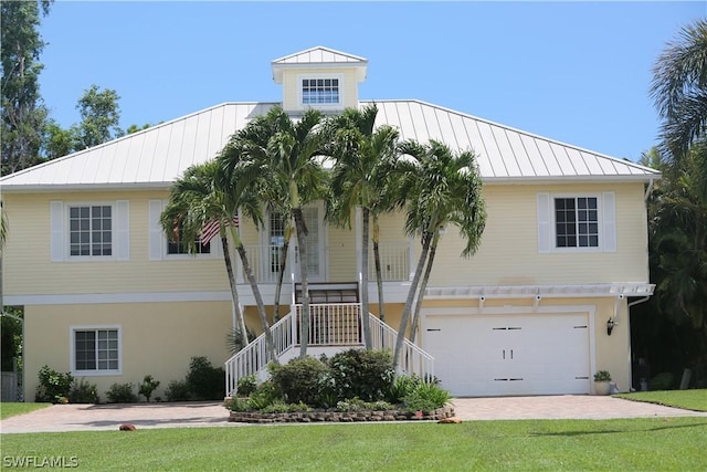 view of front facade with a garage, covered porch, and a front lawn