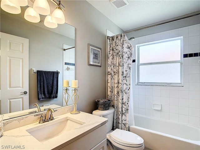 full bathroom featuring vanity, toilet, a textured ceiling, and shower / tub combo