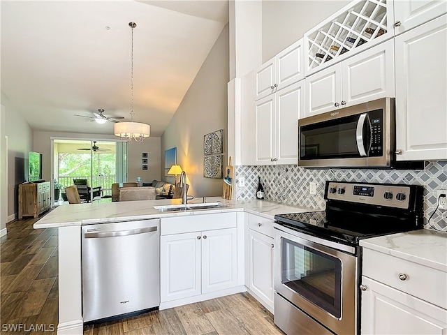 kitchen featuring kitchen peninsula, appliances with stainless steel finishes, white cabinetry, and sink