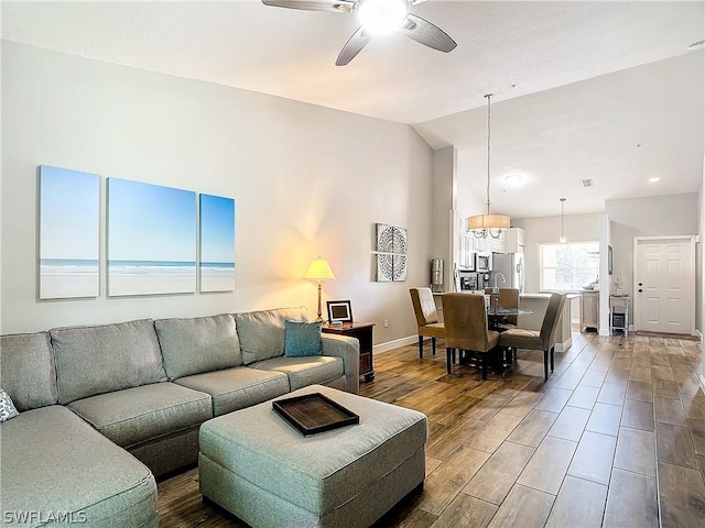 living room featuring ceiling fan and lofted ceiling