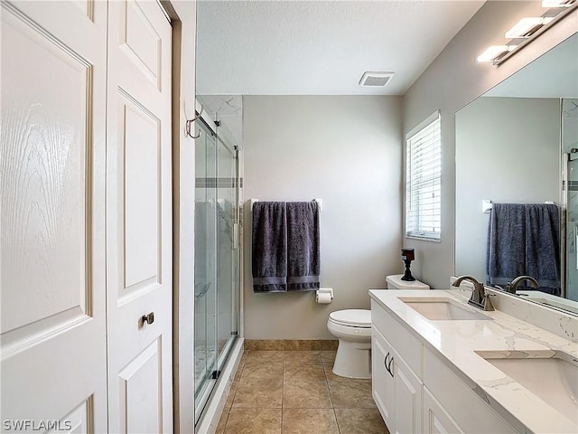 bathroom with tile patterned flooring, toilet, an enclosed shower, and vanity