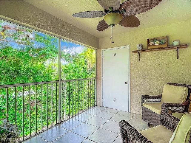 unfurnished sunroom featuring ceiling fan