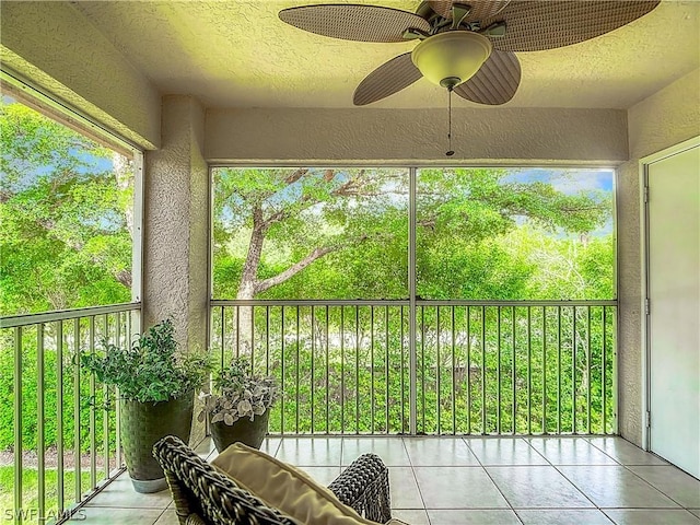 unfurnished sunroom featuring ceiling fan