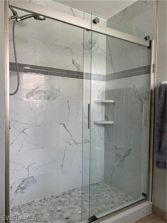 bathroom with a shower with door