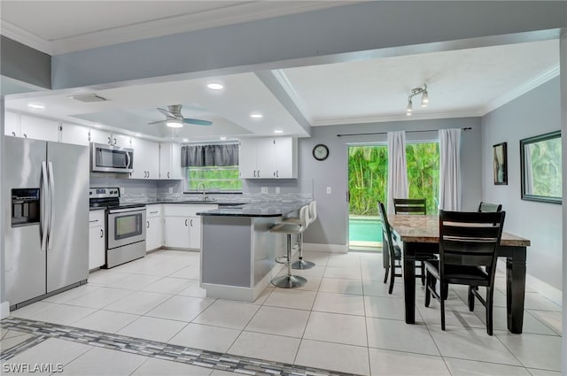 kitchen featuring white cabinetry, sink, ceiling fan, light tile patterned flooring, and appliances with stainless steel finishes