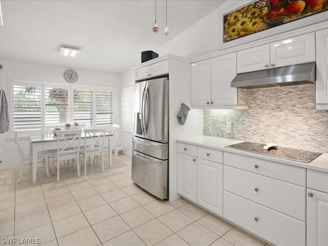 kitchen featuring white cabinetry, tasteful backsplash, electric cooktop, light tile patterned floors, and stainless steel fridge