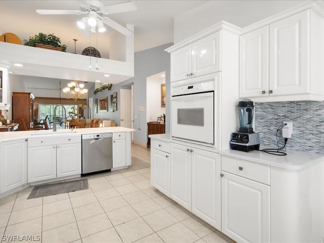 kitchen with light tile patterned flooring, sink, white cabinetry, stainless steel dishwasher, and oven