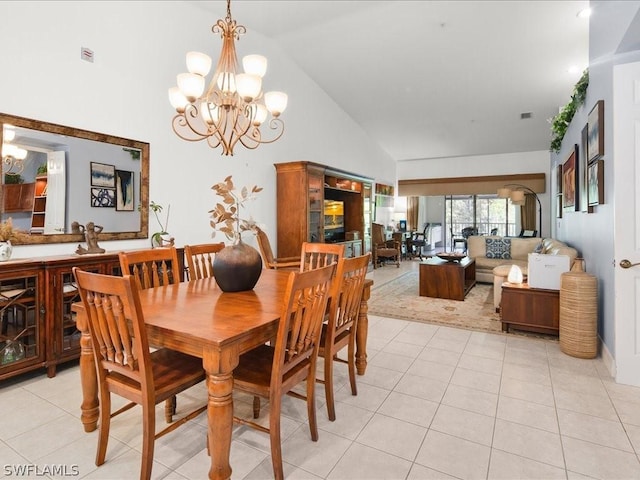 dining room featuring light tile patterned floors, high vaulted ceiling, and a chandelier