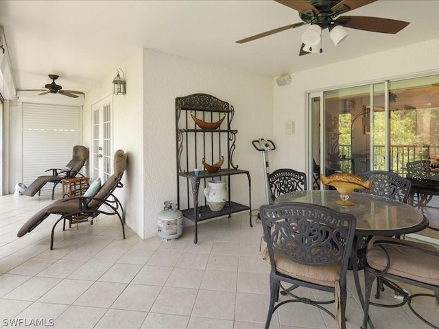 tiled dining room with ceiling fan and french doors