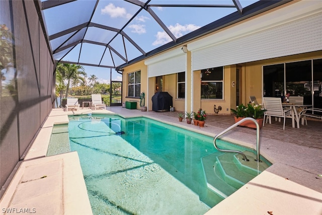 view of pool featuring a lanai, a patio area, and a grill