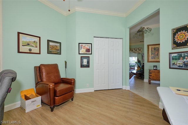 sitting room with crown molding and light hardwood / wood-style flooring