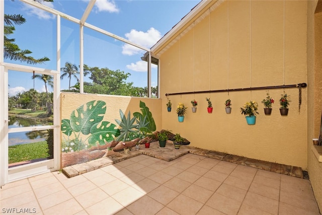 view of patio featuring a water view and glass enclosure