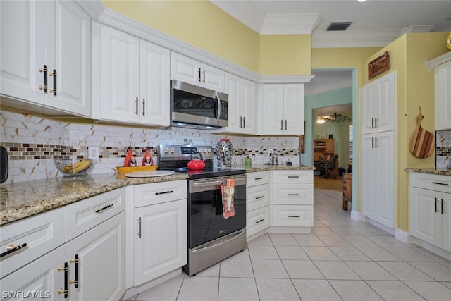 kitchen featuring crown molding, appliances with stainless steel finishes, light tile patterned flooring, light stone counters, and white cabinetry