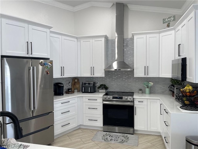 kitchen featuring appliances with stainless steel finishes, wall chimney range hood, white cabinetry, decorative backsplash, and crown molding