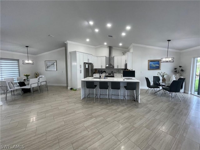 kitchen with white cabinetry, pendant lighting, stainless steel fridge, and wall chimney exhaust hood