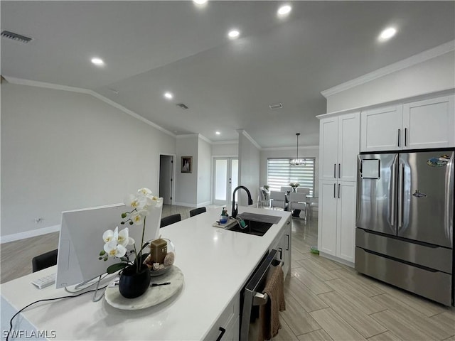 kitchen featuring stainless steel appliances, lofted ceiling, white cabinets, and sink