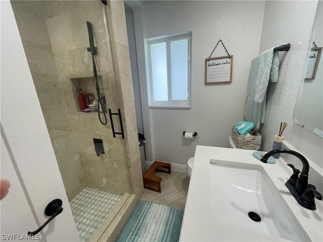 bathroom featuring sink, tiled shower, and toilet