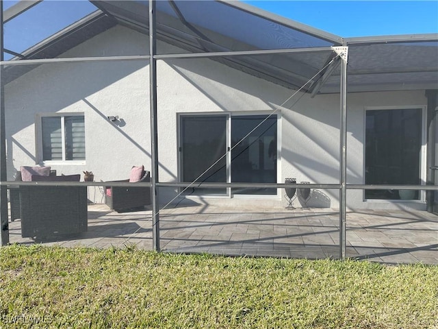 rear view of property with a lanai and a patio