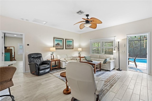 living room with a healthy amount of sunlight, ceiling fan, and light hardwood / wood-style floors