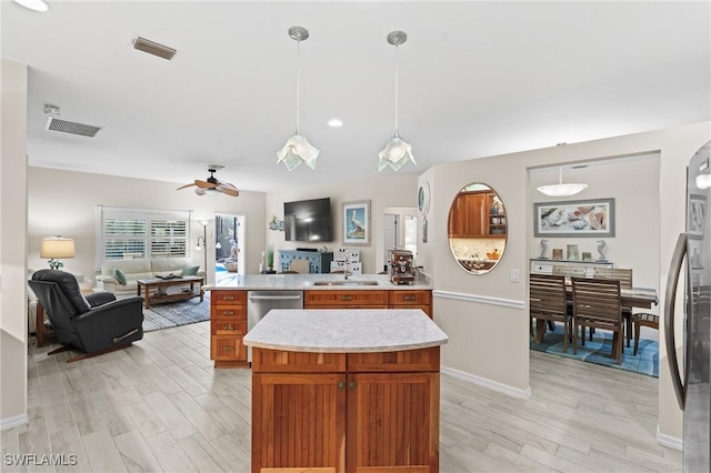 kitchen with ceiling fan, light wood-type flooring, hanging light fixtures, and appliances with stainless steel finishes