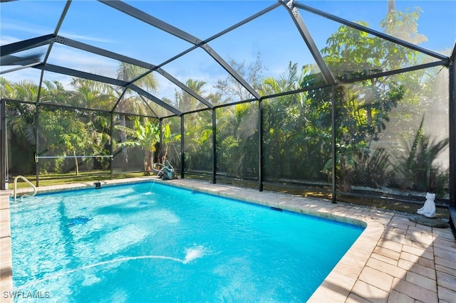 view of swimming pool featuring a lanai and a patio