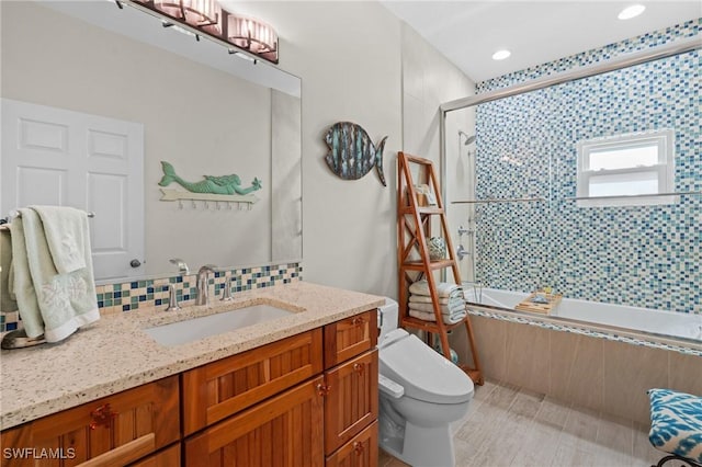 full bathroom with toilet, enclosed tub / shower combo, vanity, and decorative backsplash