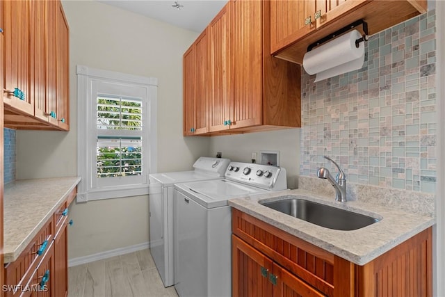 laundry area with sink, washer and clothes dryer, and cabinets