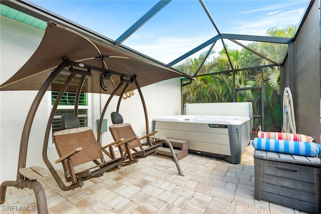 view of patio with glass enclosure and a hot tub