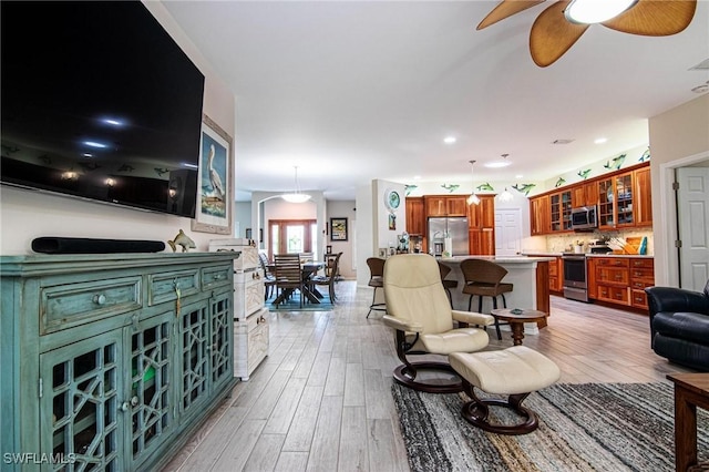 living room with ceiling fan and light hardwood / wood-style floors