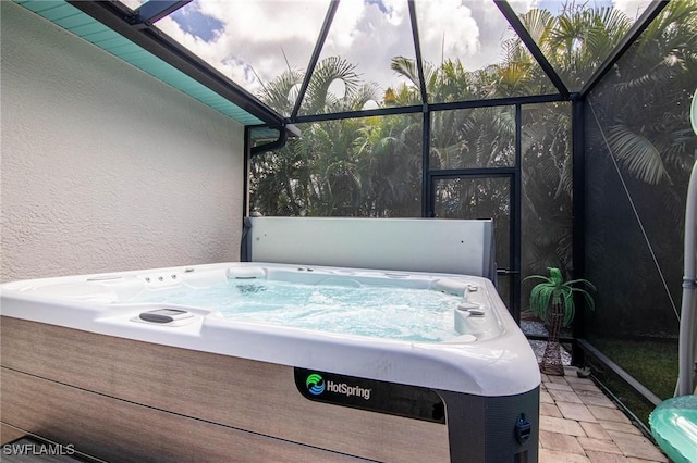 view of patio featuring a hot tub and glass enclosure