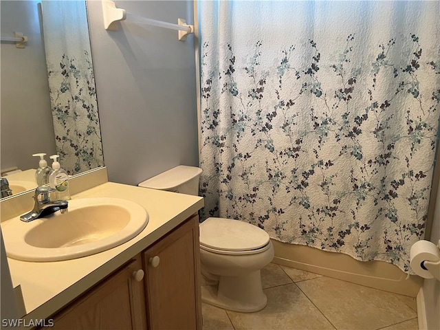 bathroom with toilet, vanity, and tile patterned floors