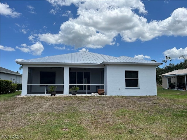 rear view of property with a yard and a sunroom