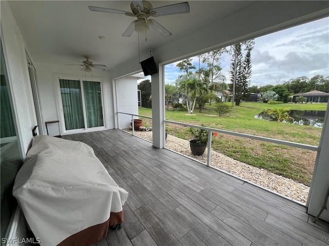 deck featuring ceiling fan, a grill, and a water view