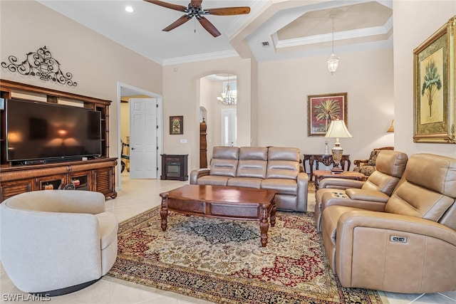 living room with ceiling fan with notable chandelier, light tile patterned flooring, and crown molding