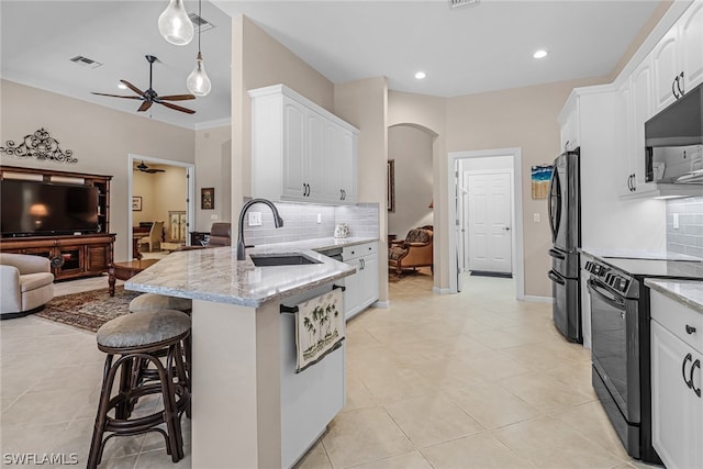 kitchen featuring light stone countertops, white cabinetry, black range with electric stovetop, and sink