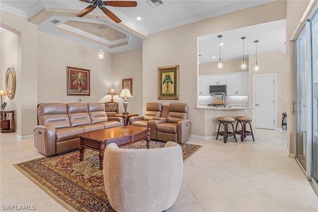 living room featuring sink, ceiling fan, ornamental molding, and light tile patterned flooring