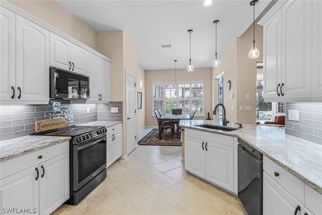 kitchen with a wealth of natural light, white cabinetry, sink, hanging light fixtures, and black appliances