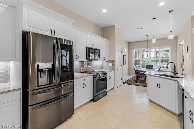 kitchen featuring sink, stainless steel appliances, light stone counters, pendant lighting, and white cabinets