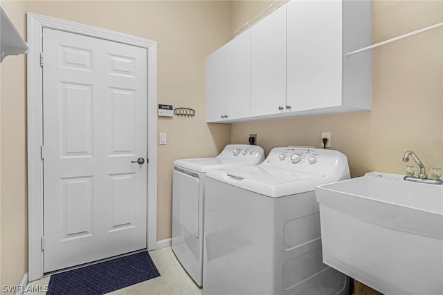 laundry room featuring cabinets, independent washer and dryer, and sink