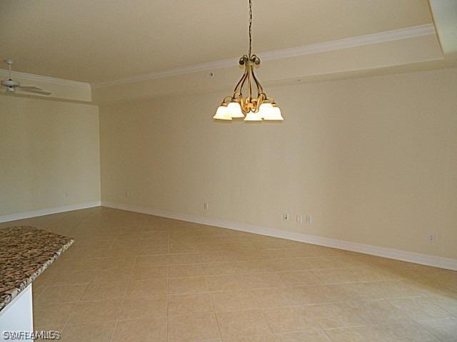 tiled spare room featuring crown molding and a chandelier