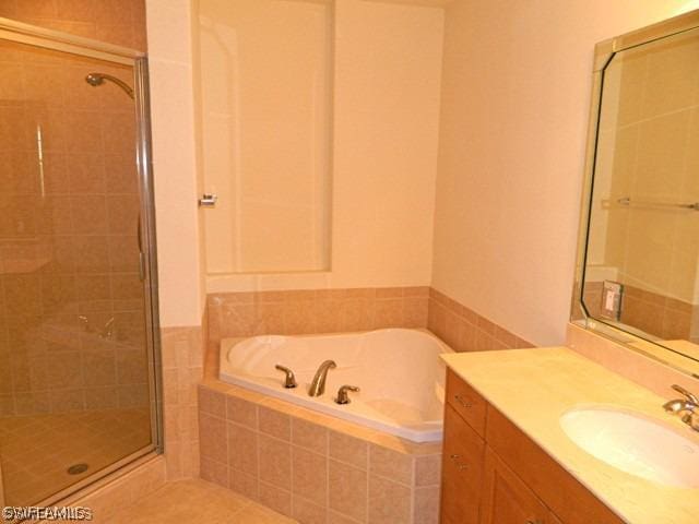 bathroom with separate shower and tub, vanity, and tile floors