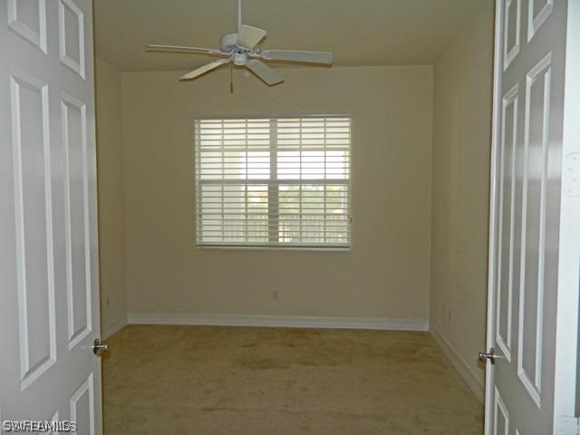 carpeted empty room featuring ceiling fan